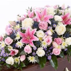 Oriental lily, cream rose  and eryngium casket spray