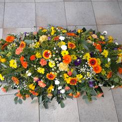 Bright casket spray in orange, yellow and purple 